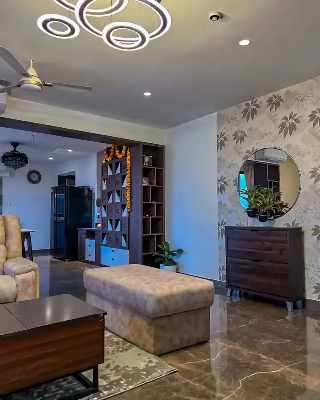 A living room with deep upholstered seating, a low table and circular ceiling lights